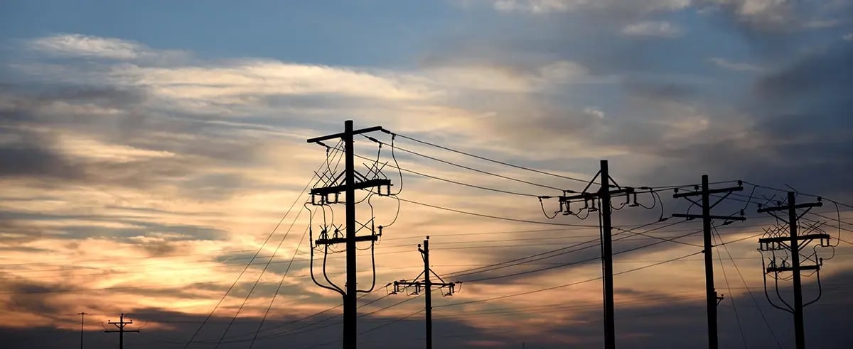 Power poles against calm evening sky