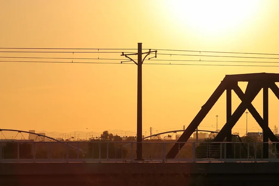 A smoky sky with power pole in the foreground, cityscape in the background.